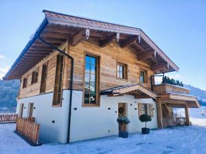 a log home in the snow in the winter at Chalet Magdalena in Kirchberg in Tirol