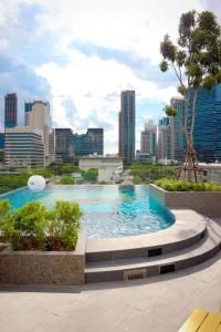 a swimming pool with a city in the background at The Quart Ruamrudee by UHG in Bangkok