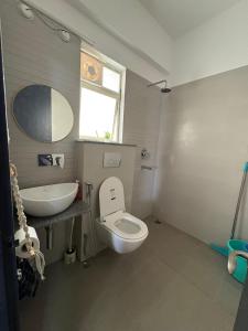 a bathroom with a white toilet and a sink at Live Easy in Siliguri