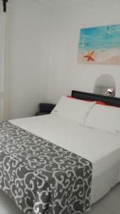 a white bed with a black and white comforter at Bed & Breakfast Dimora Felice in Ostuni