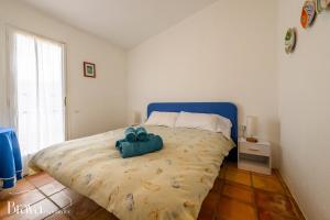 a bedroom with a bed with two blue towels on it at Can Rino - Vistas panorámicas I piscina I tenis I terraza I Brava Experience in Cadaqués