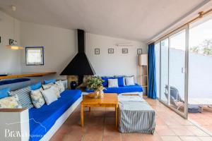 a living room with a blue couch and a table at Can Rino - Vistas panorámicas I piscina I tenis I terraza I Brava Experience in Cadaqués