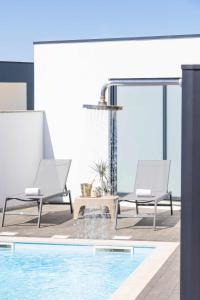 two chairs sitting next to a swimming pool at Dunes Beach House with Ocean Views in Viana do Castelo +42 photos
