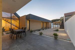 a house with a patio with a table and chairs at Dunes Beach House with Ocean Views in Viana do Castelo