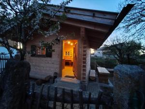 a tiny house with a yellow door at night at Blockhütte bei den Hühnchen in Rötz