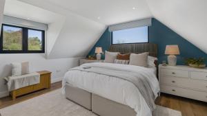 a bedroom with a large bed with a blue accent wall at Ferny Retreat in Bromyard