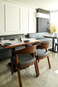 a dining room with a wooden table and chairs at Mastiff Hotel Crystara, Jalgaon in Jālgaon