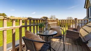 a patio with chairs and a table on a deck at Ferny Retreat in Bromyard
