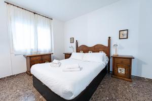 a bedroom with a large bed with white sheets and two tables at Olot céntrico, La Garrotxa, Petfriendly in Olot