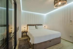 a white bedroom with a bed and a table at Apartments Barbara Kraljevica in Kraljevica