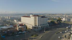 a large white building in a city with a street at Haile Hotel Debre Birhan in Debre Birhan