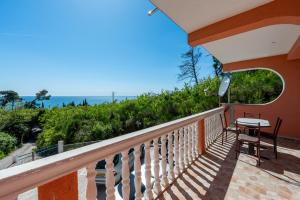 a balcony of a house with a table and chairs at Benelux Apartments Bar in Šušanj