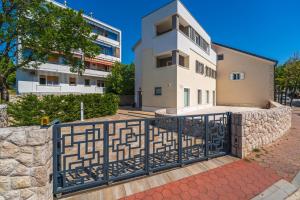 a house with a gate in front of a building at Apartments Barbara Kraljevica in Kraljevica