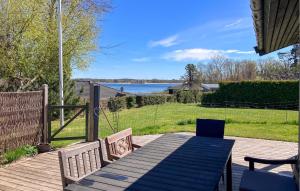 a table and chairs on a deck with a view of the water at Stunning Home In Hundested With Wifi in Hundested