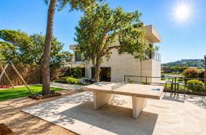 a picnic table in front of a house with a swing at Naramia Sagaro Villa - with Pool-garden-10 Pax in S'agaro