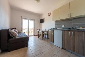 a kitchen and living room with a couch and a table at Benelux Apartments Bar in Šušanj