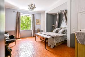 a bedroom with a bed and a table and a window at Château De Jouques in Gémenos +52 photos