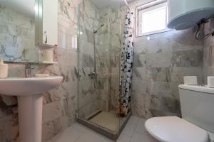a bathroom with a shower and a toilet and a sink at Benelux Apartments Bar in Šušanj +51 photos
