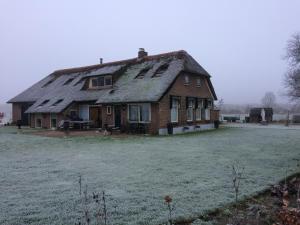 an old house with a thatched roof on a field at B&B op Wijngoed Havelte in Havelte