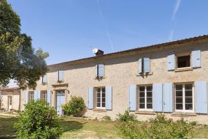 an old brick building with white shutters on it at Chambres en Charente Maritime in Loiré-sur-Nie