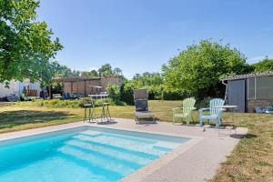 a swimming pool with chairs and a table and a table and chairs at Chambres en Charente Maritime in Loiré-sur-Nie