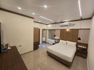 a bedroom with a bed and a desk in it at AdaraResidency in Trivandrum +10 photos