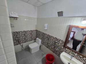 a bathroom with a toilet and a sink and a mirror at AdaraResidency in Trivandrum