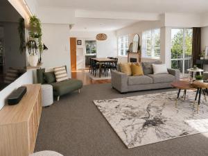 a living room with a couch and a table at Redwoods Retreat Rotorua Private 3BR Home in Rotorua