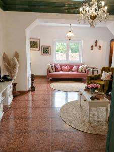 a living room with a pink couch and a table at A Encantada Spa e Vista 180 Casa de Artista in Alqueve +25 photos