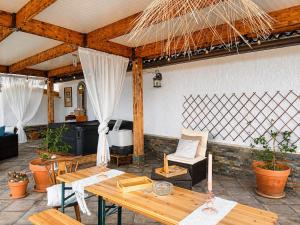 an outdoor patio with wooden tables and chairs at A Encantada Spa e Vista 180 Casa de Artista in Alqueve