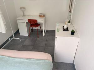 a bedroom with a desk and a red chair at Douce escale lumineuse à Nancy in Nancy