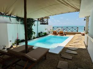 a swimming pool with a view of the ocean at ZAN Ocean View Hotel in Jambiani