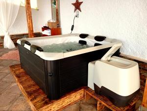 a bath tub sitting on top of a wooden floor at A Encantada Spa e Vista 180 Casa de Artista in Alqueve
