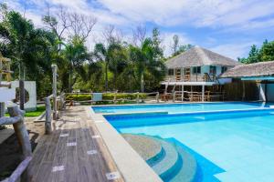 a villa with a swimming pool and a house at UNWND Boutique Hotel Calatagan in Batangas City
