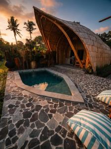 a house with a swimming pool and a building at Uma D Mapad Sidemen in Sidemen