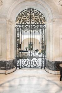 an ornate black gate in a building with a stone wall at Hotel Mercer Sevilla 5 GL in Seville