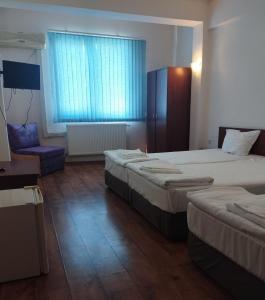 a hotel room with two beds and a chair at ХОТЕЛ РАДНЕВО in Radnevo