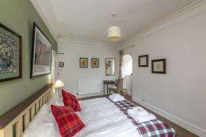 a bedroom with a bed with red pillows on it at Arduthie House in Stonehaven +11 photos