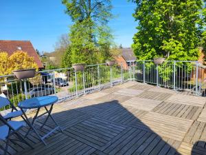 a deck with a fence and a table and chairs at Gemütliche Wohnung mit großer Dachterrasse in Röhrsen