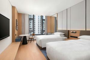 a hotel room with two beds and a flat screen tv at Four Points by Sheraton Qingtian in Qingtian +74 photos
