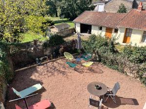 a group of chairs and an umbrella in a yard at Studio Revy 1 - Centre ville in Néris-les-Bains