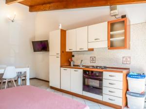 eine Küche mit weißen Schränken und einem rosa Teppich in der Unterkunft Living 68 in Forlì + 21 Fotos