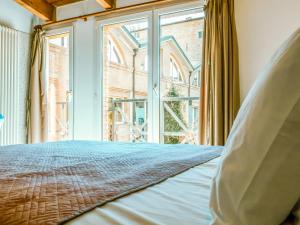 ein Schlafzimmer mit einem Bett und einem großen Fenster in der Unterkunft Living 68 in Forlì
