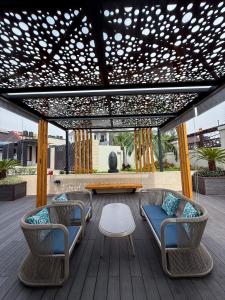 a pergola with chairs and a table on a deck at ASFARO Apartments in Abuja