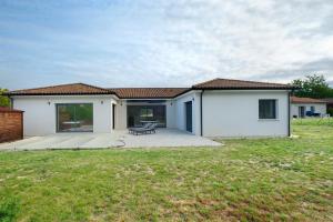 a white house with a patio and a yard at Maison Peyrelade in Coulounieix-Chamiers