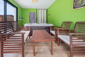 a room with chairs and a tub in a room with green walls at Maison Peyrelade in Coulounieix-Chamiers