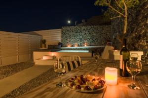 a table with a plate of food and wine glasses at Lagadi Suites Mesaria in Mesaria