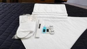 a bed with white towels and a bottle of toothpaste at Amada Family Guest House in Karachi +84 photos