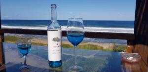 a bottle of wine and two glasses on a table at Galene Guest House in Port Shepstone