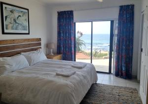 a bedroom with a bed and a view of the ocean at Galene Guest House in Port Shepstone